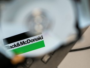 The logo for Black & McDonald is seen reflected on the plates of an open hard disk drive, in Toronto, in a Wednesday, March 8, 2023, photo illustration. A Canadian engineering giant whose work includes critical military, power and transportation infrastructure across the country has been hit with a ransomware attack.