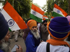 FILE- Indian Sikhs protesting against the pulling down of Indian flag from the Indian High Commission building in London gather with Indian flags outside the British High Commission in New Delhi, India, Monday, March 20, 2023. Footage posted on social media showed a man detach the Indian flag from a balcony of the building while a crowd of people below waving bright yellow "Khalistan" banners appeared to encourage him. Indian police have launched a manhunt for a Sikh separatist leader who has revived calls for an independent Sikh homeland, stirring fears of violence in northwestern Punjab state that has a history of bloody separatist insurgency.