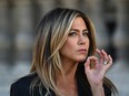 Jennifer Aniston gestures as she poses during a photocall ahead of a diner for the launch of a Louis Vuitton leather goods collection in collaboration with US artist Jeff Koons, at the Louvre in Paris on April 11, 2017.
