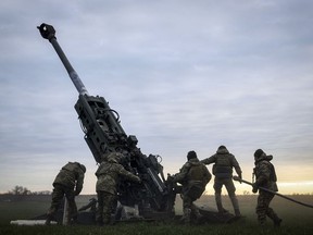 FILE - Ukrainian soldiers prepare a U.S.-supplied M777 howitzer to fire at Russian positions in Kherson region, Ukraine, Jan. 9, 2023. Quantifying the toll of Russia's war in Ukraine remains an elusive goal a year into the conflict. Estimates of the casualties, refugees and economic fallout from the war produce an complete picture of the deaths and suffering. Precise figures may never emerge for some of the categories international organizations are attempting to track.