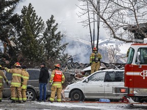Firefighters attend the scene of a house explosion that injured several people, destroyed one home and damaged others in Calgary on Monday, March 27, 2023. A leader in Calgary's South Sudanese community says efforts will be made to provide financial help to 10 people seriously injured in a house explosion.