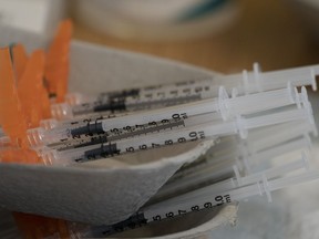 Needles are seen filled with the vaccination for COVID-19 at a truck stop on highway 91 North in Delta, B.C., Wednesday, June 16, 2021. A British Columbia pharmacist has been disciplined for falsifying provincial health records and claiming to be vaccinated against COVID-19.