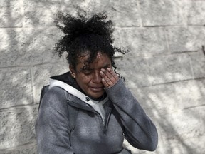 A Venezuelan migrant woman cries in front at of a Mexican immigration detention center in Ciudad Juarez, Mexico, Tuesday, March 28, 2023, where a fire in a dormitory left more than three dozen migrants dead. President Andrés Manuel López Obrador said the fire was started by migrants in protest after learning they would be deported.