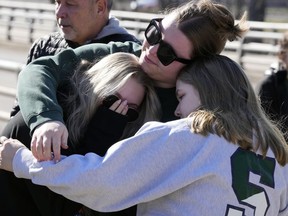 Michigan State University students embrace at The Rock on campus, Tuesday, Feb. 14, 2023, in East Lansing, Mich. Police say the gunman who killed himself hours after fatally shooting three students at Michigan State University was 43-year-old Anthony McRae. Police also say five people who are in critical condition Tuesday are also students.