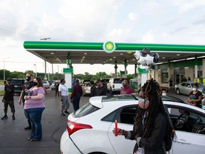 FILE - Members of the community gather for a vigil on the corner of 67th and Prospect in Kansas City, Mo., June 2, 2021, at the BP gas station where Malcolm Johnson was shot and killed by police on March 25. On Monday, March 13, 2023, it was announced that the Kansas City, Mo., police officer who fatally shot Johnson at a convenience store nearly two years ago will not be charged with a crime, following a decision by a special prosecutor.