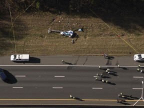 In this image take with a drone, emergency personnel work at the scene of a helicopter crash on the side of Interstate 77 South in Charlotte, N.C., Tuesday, Nov. 22, 2022. The family of a meteorologist who was killed last year in a helicopter crash in North Carolina is suing a maintenance facility and the company that owned and operated the aircraft.