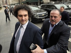 FILE - FTX founder Sam Bankman-Fried, left, arrives at Manhattan federal court on Feb. 16, 2023, in New York. In a proposal submitted Friday, March 3, 2023, prosecutors and attorneys for Bankman-Fried are requesting the disgraced cryptocurrency entrepreneur be allowed a flip-phone or another device that's not a smartphone while on bail.