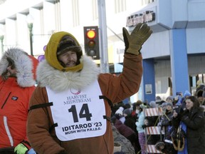 FILE - Defending champion Brent Sass, wearing bib No. 14, waves to the crowd during the Iditarod Trail Sled Dog Race's ceremonial start in downtown Anchorage, Alaska, on Saturday, March 4, 2023. Sass withdrew from this year's race, Saturday, March 11, 2023, citing concerns for his health.