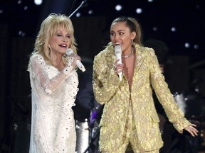 FILE - Dolly Parton, left, and Miley Cyrus perform "Jolene" at the 61st annual Grammy Awards in Los Angeles on Feb. 10, 2019. Administrators at Heyer Elementary School in Waukesha, Wis., aren't letting a first-grade class perform "Rainbowland," a Cyrus and Parton duet from Cyrus' 2017 album "Younger Now," promoting LGBTQ acceptance, because they say the song could be seen as controversial.