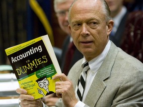 FILE - South Carolina Comptroller General Richard Eckstrom holds up a book he wanted to present to his new Chief of Staff James Holly during his introduction at the Budget and Control Board meeting, Aug. 13, 2009, in Columbia, S.C. Pressure is mounting for Eckstrom after a $3.5B accounting error.