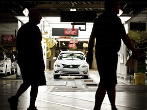 FILE - Workers at the Nissan plant in Smyrna, Tenn., walk by a Nissan Altima sedan, May 15, 2012. A group of 75 employees out of the thousands who work at a Nissan assembly plant in Tennessee will finally vote Thursday, March 16, 2023, on whether to form a union.