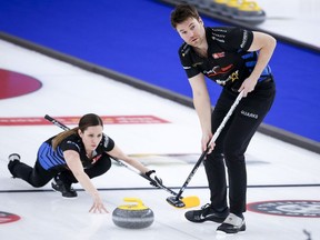 Team Walker/Muyres skip Laura Walker, left, makes a shot as third Kirk Muyres sweeps while they play Team Einarson/Gushue at the Canadian Mixed Doubles Curling Championship in Calgary, Alta., Wednesday, March 24, 2021. When Muyres decided to shift from men's team curling to mixed doubles, the upcoming Canadian championship was one of the top events circled on his calendar.