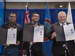 Ontario Premier Doug Ford, right, Chief Cornelius Wabasse, Webequie First Nation, left, and Chief Bruce Achneepineskum, Marten Falls First Nation, centre, show off their signed agreement regarding the Ring of Fire in Northern Ontario at the Prospectors and Developers Association of Canada's annual convention in Toronto on Monday, March 2, 2020. The province says it has approved a plan to build a road to potential mining sites in the Ring of Fire.