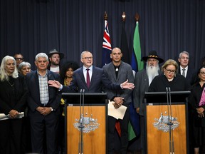 Australian Prime Minister Anthony Albanese, at the left podium, is surrounded by members of the First Nations Referendum Working Group as he speaks during a press conference at Parliament House in Canberra, Thursday, March 23, 2023. The Australian government released the wording of a referendum question that promises the nation's troubled Indigenous population a greater say on policies that effect their lives.
