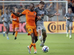Houston Dynamo midfielder Fafa Picault, left, and CF Montreal defender Gabriele Corbo try to get control of the ball during the second half of an MLS soccer match Saturday, Aug. 13, 2022, in Houston. Corbo is back with CF Montreal following a transfer from Italian club Bologna FC.