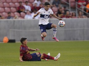 Real Salt Lake midfielder Damir Kreilach, bottom, falls as Vancouver Whitecaps defender Cristian Gutierrez collects the ball during the first half of an MLS soccer match Wednesday, July 7, 2021, in Sandy, Utah. Gutierrez has found a new home with Toronto FC.