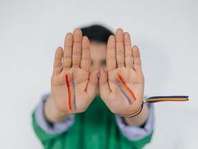Child with pride flags painted on hands