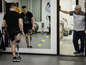 Dmytro Zilko, a soldier and a patient of the clinic exercises on a new prosthesis with rehabilitation specialist Maria in a prosthetics clinic in Kyiv,.