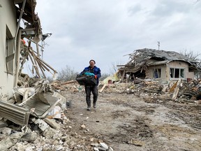 A local resident walks among the remains of residential buildings destroyed by a Russian missile strike, near the town of Zolochiv, Lviv region.