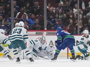 Vancouver Canucks' Andrei Kuzmenko (96) scores against San Jose Sharks goalie James Reimer (47) during the first period of an NHL hockey game in Vancouver, B.C., Thursday, March 23, 2023.