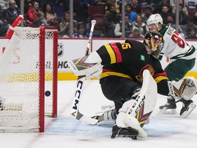Minnesota Wild's Kirill Kaprizov, back right, scores his second goal against Vancouver Canucks goalie Thatcher Demko during the second period of an NHL hockey game in Vancouver, on Thursday, March 2, 2023.
