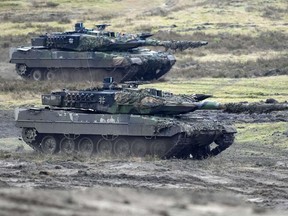 FILE - Two Leopard 2 tanks are seen in action during a visit of German Defense Minister Boris Pistorius at the Field Marshal Rommel Barracks in Augustdorf, Germany, on Feb. 1, 2023. To back future Ukrainian counterattacks, its Western allies have promised new supplies of weapons, including hundreds of tanks and other armored vehicles along with artillery, rockets and other equipment.