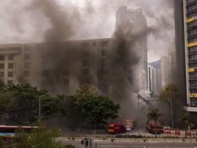 Firefighters battle a fire in Cheung Sha Wan, a residential and industrial area, in Hong Kong, Friday, March 24, 2023.