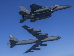 In this photo provided by South Korea Defense Ministry, a U.S. Air Force B-52H Stratofortress aircraft, bottom, flies in formation with South Korea's Air Force F-15K fighter over the western sea of Korean peninsula during a joint air drill in South Korea, March 6, 2023.