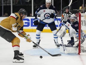 Vegas Golden Knights center William Karlsson (71) attempts a shot on Winnipeg Jets goaltender Connor Hellebuyck (37) during the second period of Game 1 of an NHL hockey Stanley Cup first-round playoff series Tuesday, April 18, 2023, in Las Vegas.