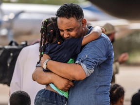 Violinist Othmano hugs his daughter before boarding an RAF C-130, that will take them to Cyprus, during the evacuation of British citizens, at Wadi Seidna airport, Sudan April 27, 2023.