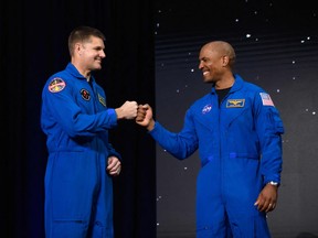 Jeremy Hansen, left, bumps fists with Victor Glover, after both were selected for the Artemis 2 mission.