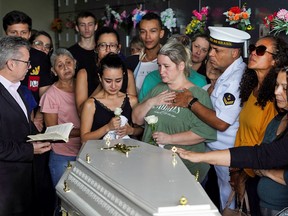 Parents stand alongside a coffin containing the remains of their 5-year-old, Bernardo Cunha Machado, who was killed by a man inside a daycare center, during a wake at the Sao Jose cemetery, in Blumenau, Brazil, April 6, 2023.