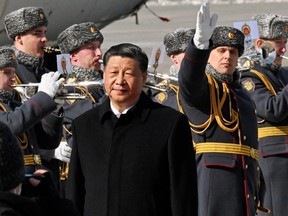 Chinese President Xi Jinping walks past honour guards and members of a military band during a welcoming ceremony upon his arrival at an airport in Moscow, Russia, March 20, 2023. Kommersant Photo/Anatoliy Zhdanov via REUTERS