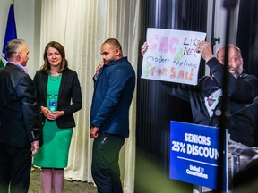 UCP leader Danielle Smith waits as protesters disrupt a press conference in Calgary on Thursday, May 11, 2023.