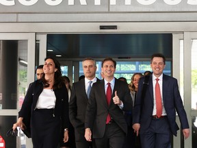 Dominion Voting Systems CEO John Poulos, second from left, leaves the courthouse with members of his legal team after a settlement was reached in a lawsuit against Fox News for defamation in Wilmington, Delaware, April 18, 2023.