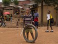 A child plays with a tire in a street in a slum on the outskirts of Kigali, Rwanda, in a file photo from 2019.