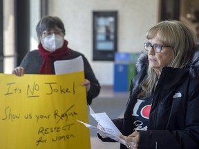 Karlene Gibson recites a poem as Bernadette Wagner holds a protest sign at a news conference regarding a controversial Experience Regina marketing campaign, at Regina City Hall on Wednesday, April 5, 2023.