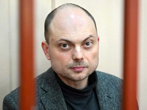 Russian opposition activist Vladimir Kara-Murza sits on a bench inside a defendants' cage during a hearing at the Basmanny court in Moscow in a file photo from Oct. 10, 2022.