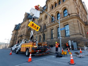 Ottawa crews reinstall traffic lights on Wellington Street in front of Parliament Hill in Ottawa. Liberal MP Yasir Naqvi says he's disappointed in the city's decision to reopen the street to traffic.