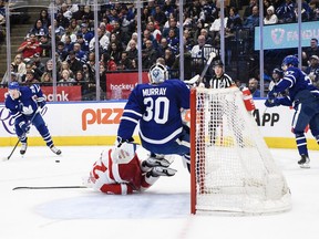 Detroit Red Wings left wing Lucas Raymond (23) collides with Toronto Maple Leafs goaltender Matt Murray (30) during first period NHL hockey action in Toronto on Sunday, April 2, 2023.