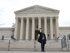 A visitor takes a selfie in front of the Supreme Court building on Capitol Hill, Monday, March 27, 2023, in Washington.