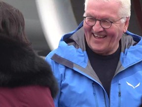 German President Frank-Walter Steinmeier, right, has a laugh speaking with someone on the tarmac after arriving in Yellowknife, Wednesday, April 26, 2023.