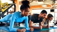 Women and man in sportswear doing plank exercise on rubber mat in fitness club. Should gym memberships receive a tax credit?