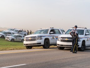 Police and investigators are seen at the side of the road outside Rosthern, Sask., on Wednesday, Sept. 7, 2022. Eleven people were killed and 17 were injured during a stabbing rampage on the James Smith Cree Nation and in the nearby village of Weldon, Sask., last year. Myles Sanderson, who police say carried out the attacks, later died in police custody.