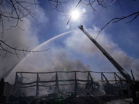 Firefighters pour water on an industrial fire in Richmond, Ind., Thursday, April 13, 2023. Multiple fires that began burning Tuesday afternoon were still burning within about 14 acres of various types of plastics stored inside and outside buildings at the former factory site.