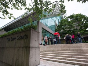 Media wait outside B.C. Supreme Court, in Vancouver, B.C., on Tuesday June 2, 2015. A man accused of the first-degree murder of a Burnaby, B.C., teenager six years ago repeatedly denied killing the girl as his trial started Wednesday.