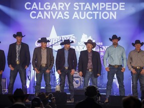 Chuckwagon drivers line-up on stage prior to the bidding at the Calgary Stampede chuckwagon canvas auction in Calgary, Thursday, April 13, 2023. This year's Stampede runs from July 7-16.