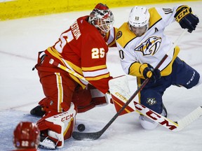 Nashville Predators forward Colton Sissons, right, tries to get the puck past Calgary Flames goalie Jacob Markstrom during second period NHL hockey action in Calgary, Monday, April 10, 2023.THE CANADIAN PRESS/Jeff McIntosh