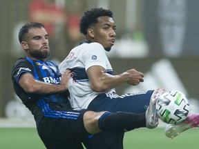 Vancouver Whitecaps forward Theo Bair (right) fights for control of the ball with Montreal Impact defender Rudy Camacho during the first half of MLS soccer action in Vancouver, B.C. Sunday, September 13, 2020.