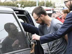 Steeve Gagnon is escorted by police out of court in Amqui, Que., Tuesday, March 14, 2023. Gagnon is facing charges relating to an incident where a driver of a pickup truck drove into pedestrians, killing two people and injuring nine.